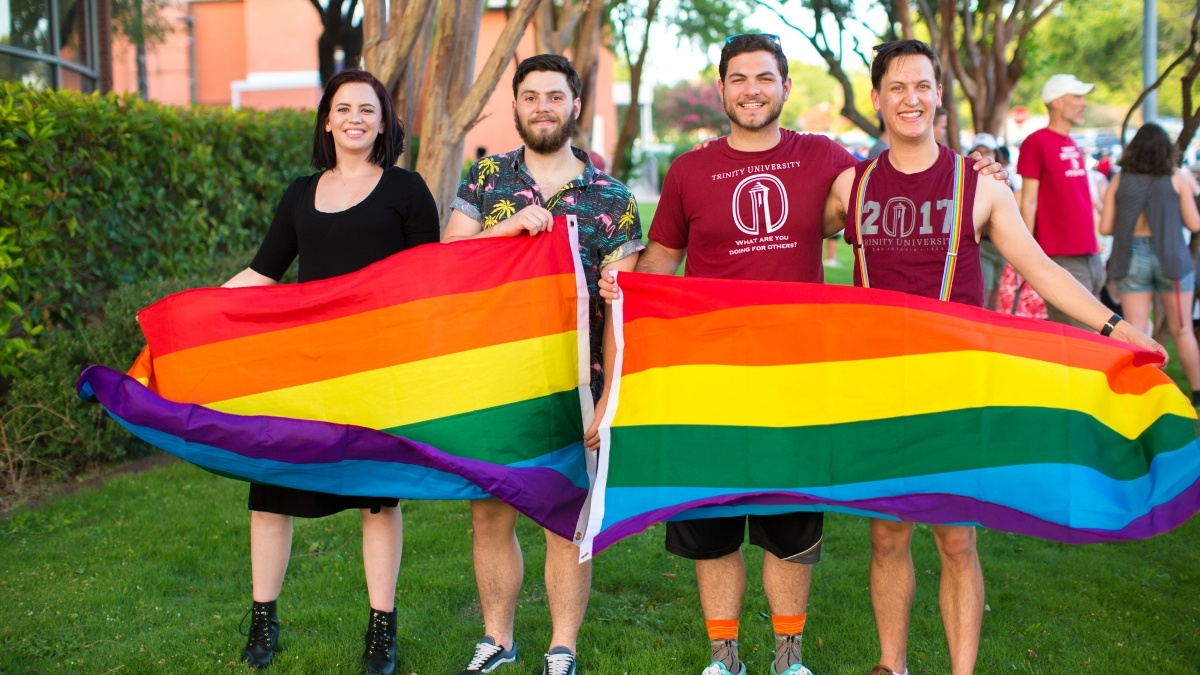 A group of students pose with pride flags